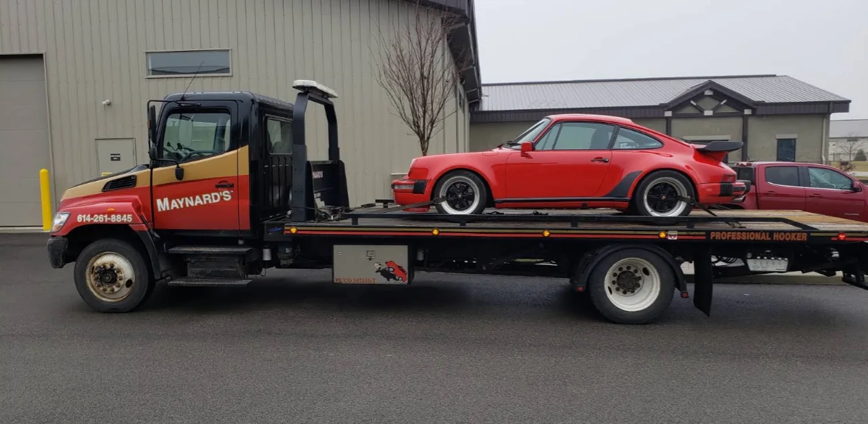 Maynard's flatbed towing a red Porsche