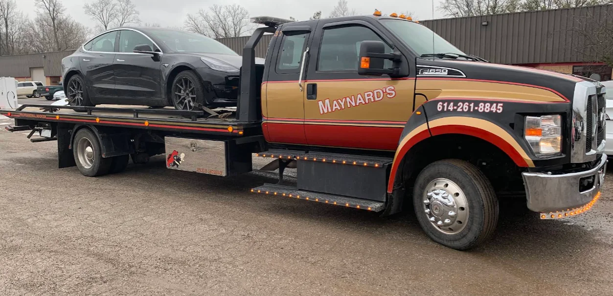 Maynard's flatbed carrying a Tesla sedan
